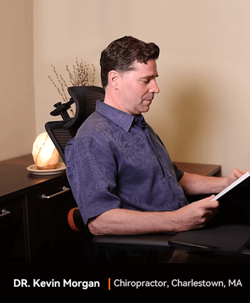 DR Kevin Morgan is sitting on a Newtral chair reading a book